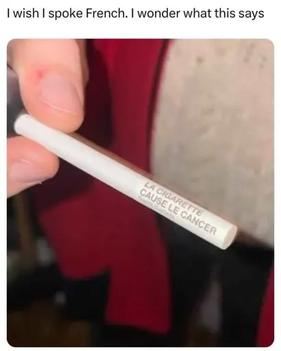 "I wish I spoke French. I Wonder what this says" says the caption above a photo of someone holding a cigarette. On the cigarette it says "la cigarette cause le cancer"